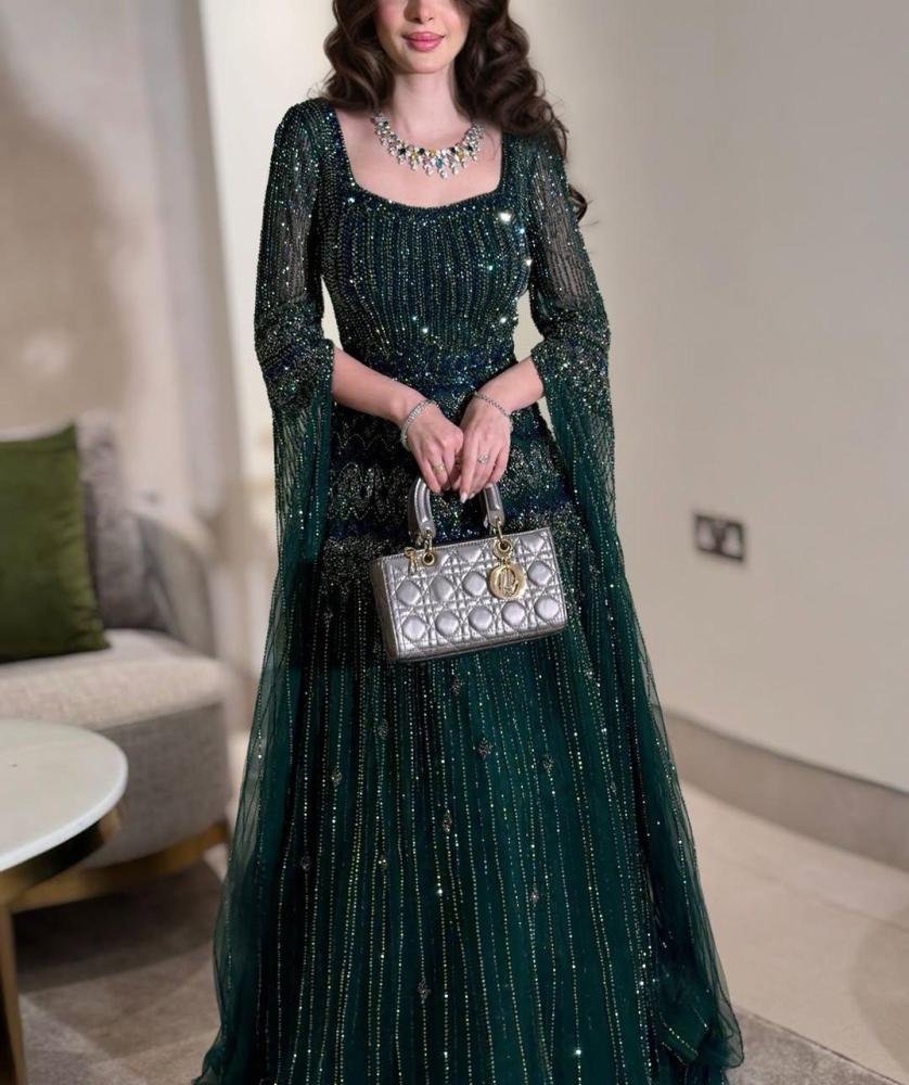 2b40cb29-19b8-4abb-b124-ac7ede0928ff-838.28125x1000-QF4G5nWyFjE5TIpGXgY65d70IO6wKJe59qX4QG9G.jpg فستان سهرة أخضر زمردي مطرز بلمسة ملكية - الصورة 1