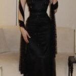 فستان سهرة أسود راقٍ بقصة هولتر وشال شيفون مطرز