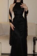 فستان سهرة أسود راقٍ بقصة هولتر وشال شيفون مطرز