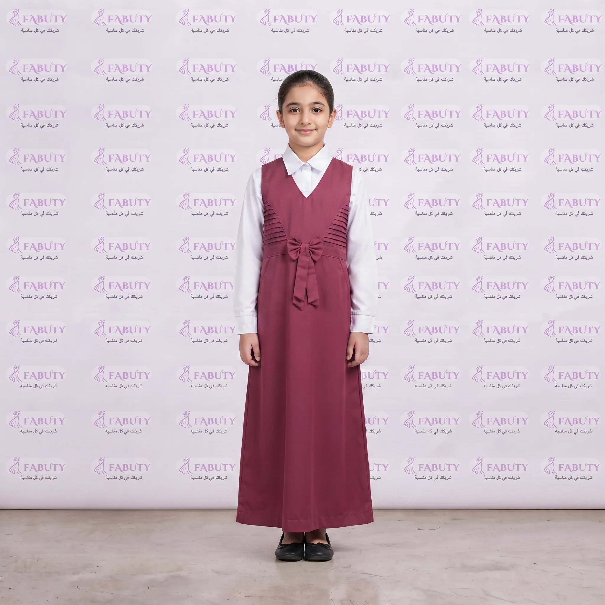 Girl_in_maroon_dress_standing_202607301729 مريول مدرسي خليجي 2ق وردي ابتدائي - الصورة 1